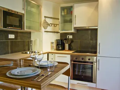 a kitchen with two plates on a wooden table at Bel appartement 3 étoiles avec balcon au cœur de Chamonix - FR-1-343-165 in Chamonix-Mont-Blanc