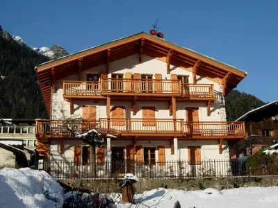 a large wooden building with a balcony in the snow at Appartement spacieux à Chamonix, 3 chambres, WiFi - FR-1-343-176 in Chamonix-Mont-Blanc