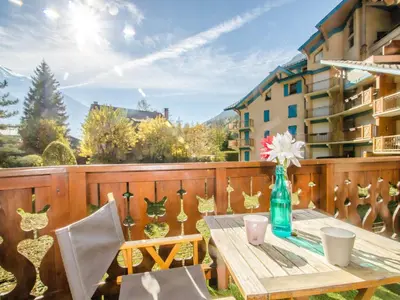 a wooden deck with a wooden table and chairs at Bel appartement au cœur de Chamonix, près des pistes, avec parking - FR-1-343-163 in Chamonix-Mont-Blanc