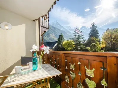 a table on a balcony with a view of mountains at Bel appartement au cœur de Chamonix, près des pistes, avec parking - FR-1-343-163 in Chamonix-Mont-Blanc