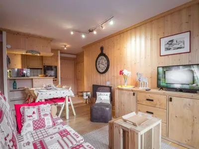 a living room with a television and a table with a table at Bel appartement au cœur de Chamonix, près des pistes, avec parking - FR-1-343-163 in Chamonix-Mont-Blanc