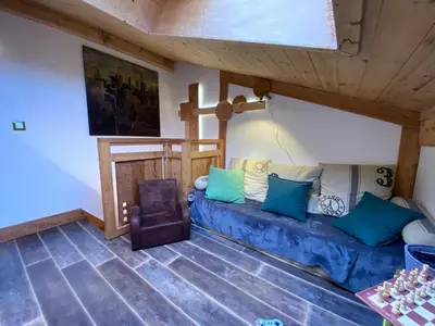 a living room with a blue couch and a chair at Bel duplex à Chamonix avec poêle à bois, WiFi, parking - FR-1-343-166 in Chamonix-Mont-Blanc