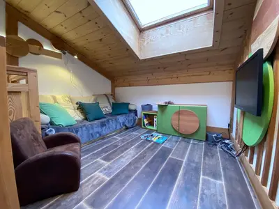 a living room with a couch and a flat screen tv at Bel duplex à Chamonix avec poêle à bois, WiFi, parking - FR-1-343-166 in Chamonix-Mont-Blanc