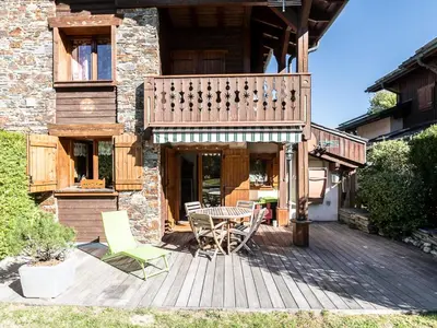 a wooden deck with a table and chairs on it at Bel duplex à Chamonix avec poêle à bois, WiFi, parking - FR-1-343-166 in Chamonix-Mont-Blanc