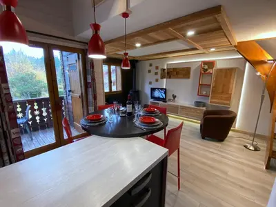 a kitchen and living room with a table and chairs at Bel duplex à Chamonix avec poêle à bois, WiFi, parking - FR-1-343-166 in Chamonix-Mont-Blanc