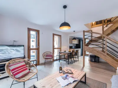 a living room with a staircase and a table at Duplex 3 étoiles pour 6 pers, Chamonix, parking privé - FR-1-343-189 in Chamonix-Mont-Blanc