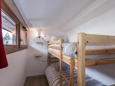 two bunk beds in a small room with a window at Duplex 3 étoiles pour 6 pers, Chamonix, parking privé - FR-1-343-189 in Chamonix-Mont-Blanc
