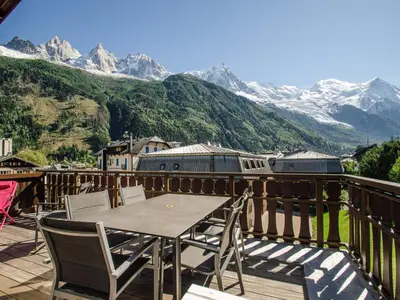 a table and chairs on a balcony with mountains at Appartement Chamonix, terrasse, 4 pers, parking privé - FR-1-343-172 in Chamonix-Mont-Blanc