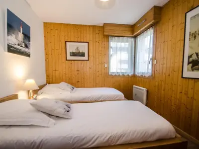 two beds in a room with wooden walls and windows at Appartement Chamonix, terrasse, 4 pers, parking privé - FR-1-343-172 in Chamonix-Mont-Blanc