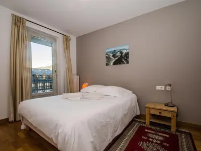 a bedroom with a large white bed and a window at Charmant duplex au cœur de Chamonix avec wifi et animaux admis - FR-1-343-183 in Chamonix-Mont-Blanc