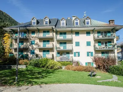 a large apartment building with a lawn in front of it at Charmant duplex au cœur de Chamonix avec wifi et animaux admis - FR-1-343-183 in Chamonix-Mont-Blanc