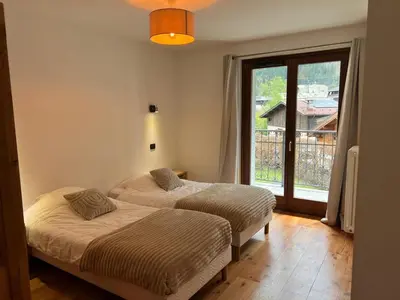 two beds in a room with a window at Charmant appartement au cœur de Chamonix avec parking et animaux acceptés - FR-1-343-187 in Chamonix-Mont-Blanc