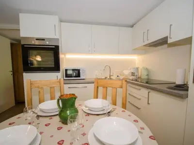 a kitchen with a table with plates and glasses on it at Appartement rénové avec vue Mont-Blanc, parking et WiFi à Chamonix - FR-1-343-206 in Chamonix-Mont-Blanc