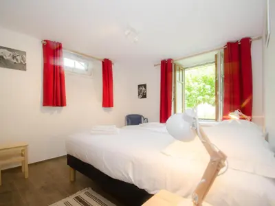 a bedroom with two beds and a window with red curtains at Appartement rénové avec vue Mont-Blanc, parking et WiFi à Chamonix - FR-1-343-206 in Chamonix-Mont-Blanc