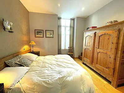 a bedroom with a large bed and a wooden cabinet at Superbe 4* Appartement de 3 Chambres au Cœur de Chamonix avec Wifi - FR-1-343-186 in Chamonix-Mont-Blanc