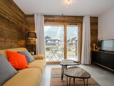 a living room with a couch and a large window at Appartement chalet à Chamonix avec wifi et parking privé - FR-1-343-201 in Chamonix-Mont-Blanc
