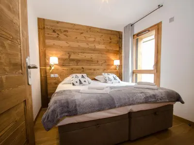 a bedroom with a bed with a wooden wall at Appartement chalet à Chamonix avec wifi et parking privé - FR-1-343-201 in Chamonix-Mont-Blanc