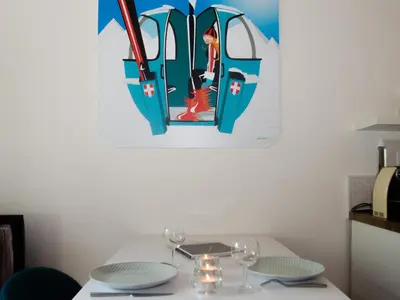 a table with two glasses and a painting on the wall at Charmant appartement à Chamonix avec parking, proche du centre - FR-1-343-203 in Chamonix-Mont-Blanc