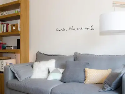 a living room with a gray couch with pillows at Charmant appartement à Chamonix avec parking, proche du centre - FR-1-343-203 in Chamonix-Mont-Blanc