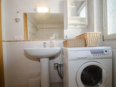 a bathroom with a washing machine and a sink at Appartement calme en centre-ville avec terrasse et vue Mont-Blanc, Chamonix - FR-1-343-198 in Chamonix-Mont-Blanc