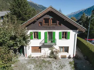 a white house with green shutters on it at Appartement central à Chamonix avec parking et wifi, proche pistes - FR-1-343-194 in Chamonix-Mont-Blanc