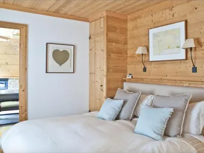 a bedroom with a large bed with wooden walls at Superbe appartement avec cheminée à Argentière - FR-1-343-192 in Chamonix-Mont-Blanc