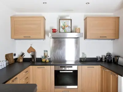 a kitchen with wooden cabinets and a stove top oven at Superbe appartement avec cheminée à Argentière - FR-1-343-192 in Chamonix-Mont-Blanc