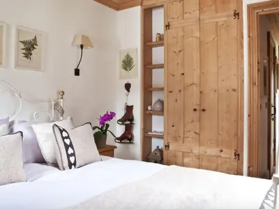 a bedroom with a white bed and a wooden door at Superbe appartement avec cheminée à Argentière - FR-1-343-192 in Chamonix-Mont-Blanc