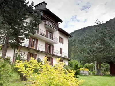 a large white building with balconies and trees at Superbe appartement avec cheminée à Argentière - FR-1-343-192 in Chamonix-Mont-Blanc