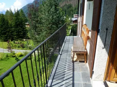 a balcony with a wooden table and a bench at Superbe appartement avec cheminée à Argentière - FR-1-343-192 in Chamonix-Mont-Blanc