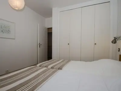 a bedroom with a large white bed and a closet at Appartement Chamonix 3* - 4 pers. + Animaux admis - FR-1-343-216 in Chamonix-Mont-Blanc