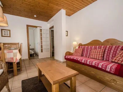 a living room with a red couch and a table at Appartement Chamonix 3* - 4 pers. + Animaux admis - FR-1-343-216 in Chamonix-Mont-Blanc