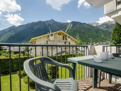 a table and chairs on a balcony with mountains at Appartement calme 3 étoiles avec Wi-Fi et parking, Chamonix - FR-1-343-212 in Chamonix-Mont-Blanc