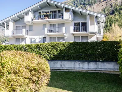 a large white building with bushes in front of it at Appartement calme 3 étoiles avec Wi-Fi et parking, Chamonix - FR-1-343-212 in Chamonix-Mont-Blanc