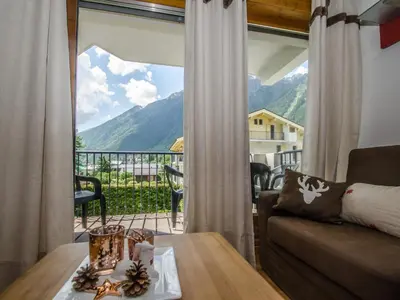 a living room with a couch and a large window at Appartement calme 3 étoiles avec Wi-Fi et parking, Chamonix - FR-1-343-212 in Chamonix-Mont-Blanc