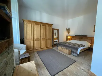 a bedroom with a bed and a wooden cabinet at Superbe appartement Chamonix pour 4, balcon, vue Mont Blanc - FR-1-343-209 in Chamonix-Mont-Blanc