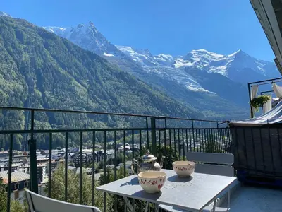 a balcony with a table and chairs and mountains at Superbe appartement Chamonix pour 4, balcon, vue Mont Blanc - FR-1-343-209 in Chamonix-Mont-Blanc