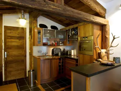 a kitchen with wooden cabinets and a counter top at Superbe appartement Chamonix pour 4, balcon, vue Mont Blanc - FR-1-343-209 in Chamonix-Mont-Blanc