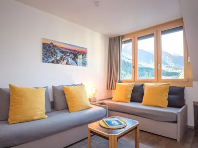 a living room with two blue couches and yellow pillows at Charmant appartement à Chamonix avec parking et wifi - FR-1-343-208 in Chamonix-Mont-Blanc