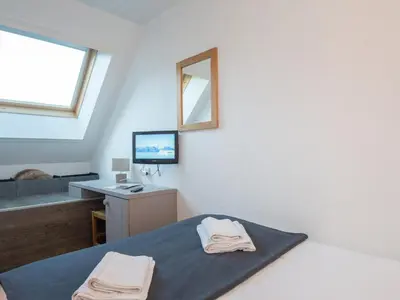 a bedroom with a bed and a desk and a mirror at Charmant appartement à Chamonix avec parking et wifi - FR-1-343-208 in Chamonix-Mont-Blanc