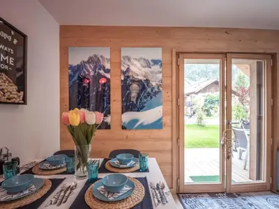 a dining room with a table with flowers on it at Bel appartement 3 étoiles aux Praz de Chamonix, près du téléphérique de la Flégère - FR-1-343-213 in Chamonix-Mont-Blanc