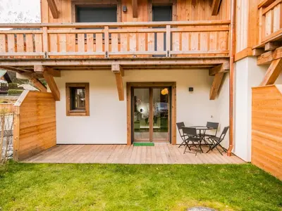 a deck with a table and chairs on a house at Bel appartement 3 étoiles aux Praz de Chamonix, près du téléphérique de la Flégère - FR-1-343-213 in Chamonix-Mont-Blanc