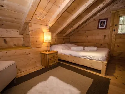 a bedroom in a log cabin with a bed and a lamp at Charmant mazot avec jardin, animaux admis, parking, wifi - FR-1-343-215 in Chamonix-Mont-Blanc