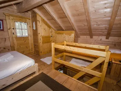 a log cabin bedroom with a bed and a desk at Charmant mazot avec jardin, animaux admis, parking, wifi - FR-1-343-215 in Chamonix-Mont-Blanc