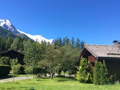 a log cabin with a snow covered mountain in the background at Charmant mazot avec jardin, animaux admis, parking, wifi - FR-1-343-215 in Chamonix-Mont-Blanc