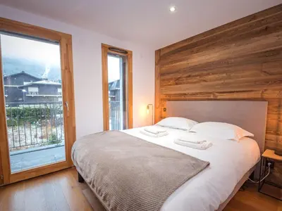 a bedroom with a large bed with a large window at Appartement moderne avec balcon et parking à Chamonix - FR-1-343-220 in Chamonix-Mont-Blanc