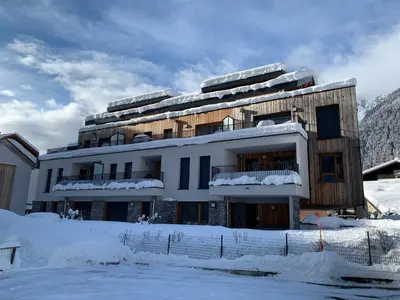 a building with snow on the ground in front of it at Appartement moderne avec balcon et parking à Chamonix - FR-1-343-220 in Chamonix-Mont-Blanc