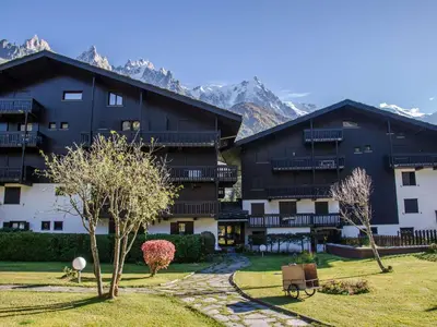 a large building with mountains in the background at Bel appartement 4 pers avec parking et balcon à Chamonix - FR-1-343-214 in Chamonix-Mont-Blanc
