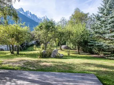 a garden with rocks and trees with mountains in the background at Chalet de charme à Chamonix avec WiFi et parking privé pour 12 pers. - FR-1-343-226 in Chamonix-Mont-Blanc
