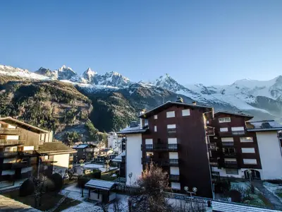 a view of a building with mountains in the background at Studio cosy 3 pers, ski-in/ski-out Chamonix avec wifi et animaux admis - FR-1-343-217 in Chamonix-Mont-Blanc